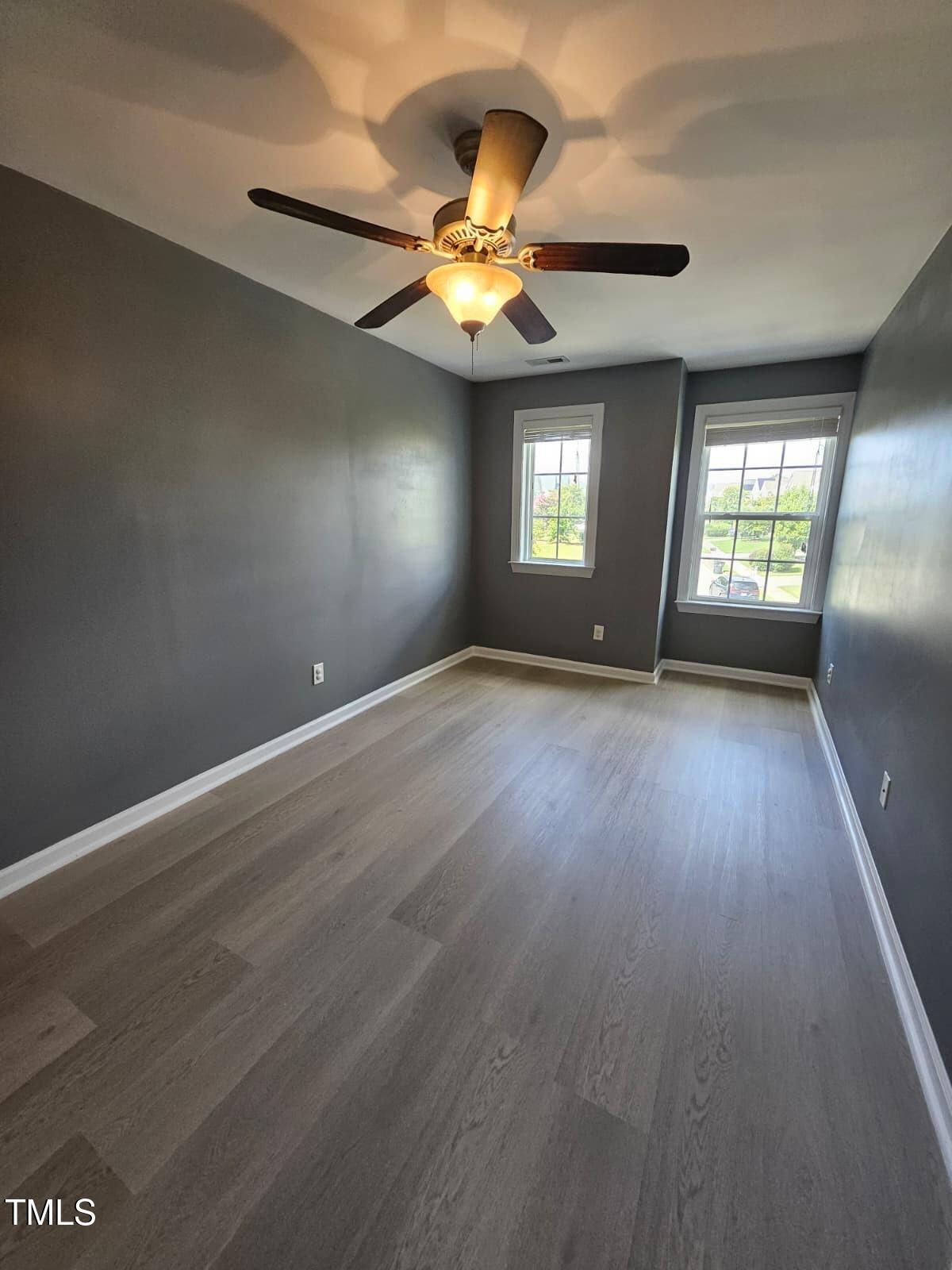 2205 Kirkhaven Road Morrisville, NC 27560 - Photo 19 of 36 an empty room with wooden floor fan and windows