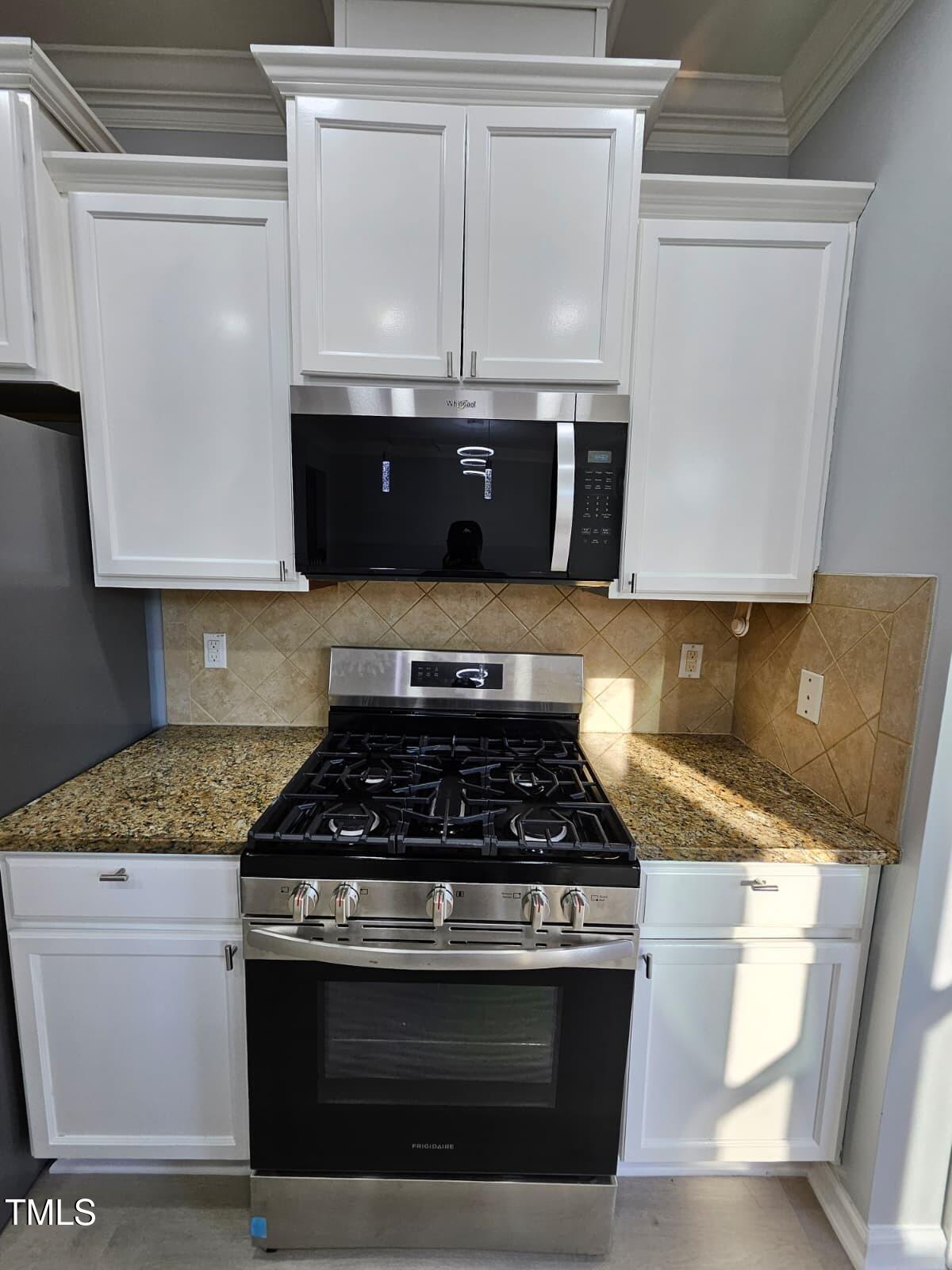 2205 Kirkhaven Road Morrisville, NC 27560 - Photo 8 of 36 a kitchen with granite countertop stainless steel appliances a stove a microwave a sink and cabinets
