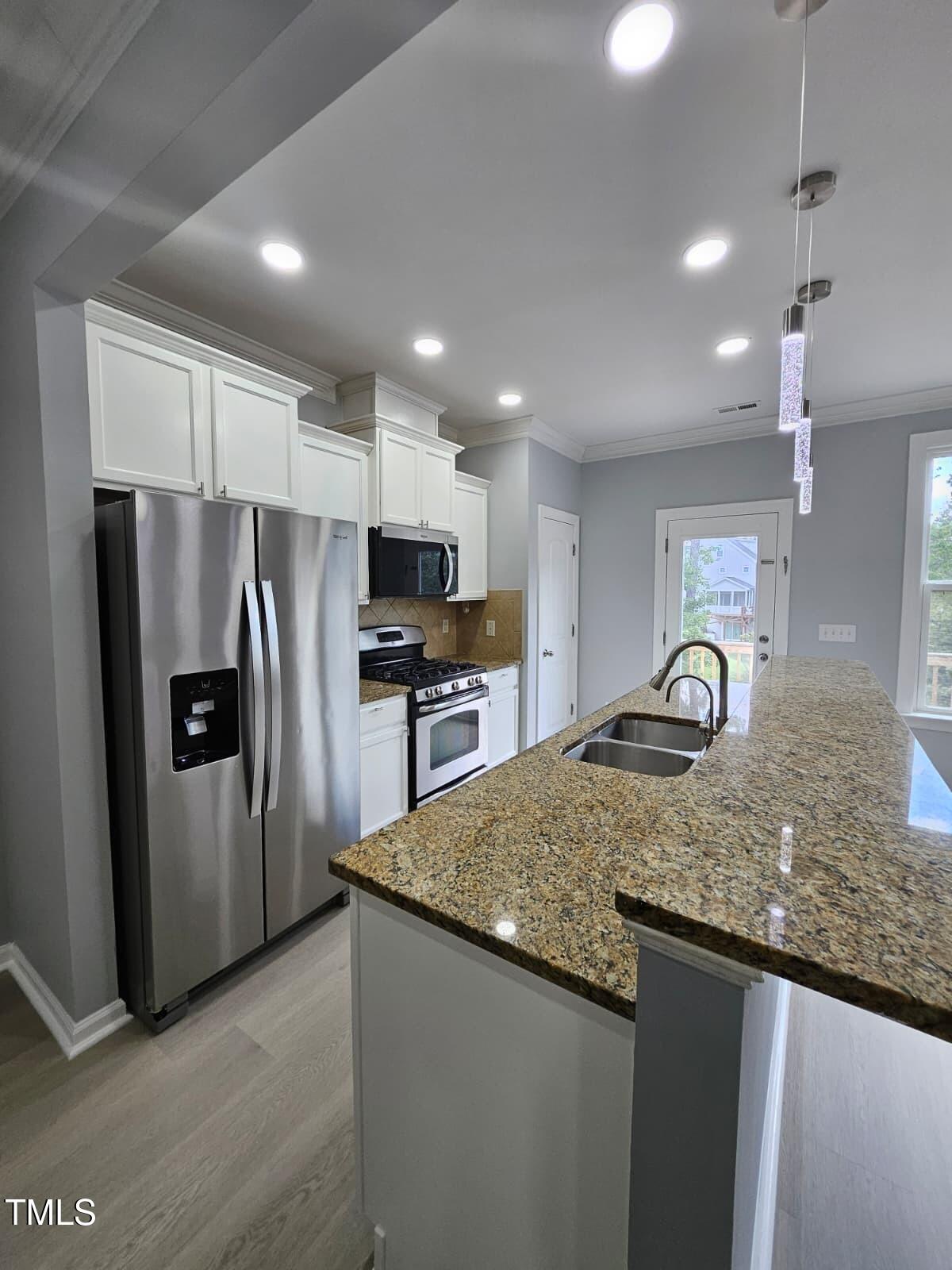2205 Kirkhaven Road Morrisville, NC 27560 - Photo 9 of 36 a kitchen with granite countertop a refrigerator and a sink