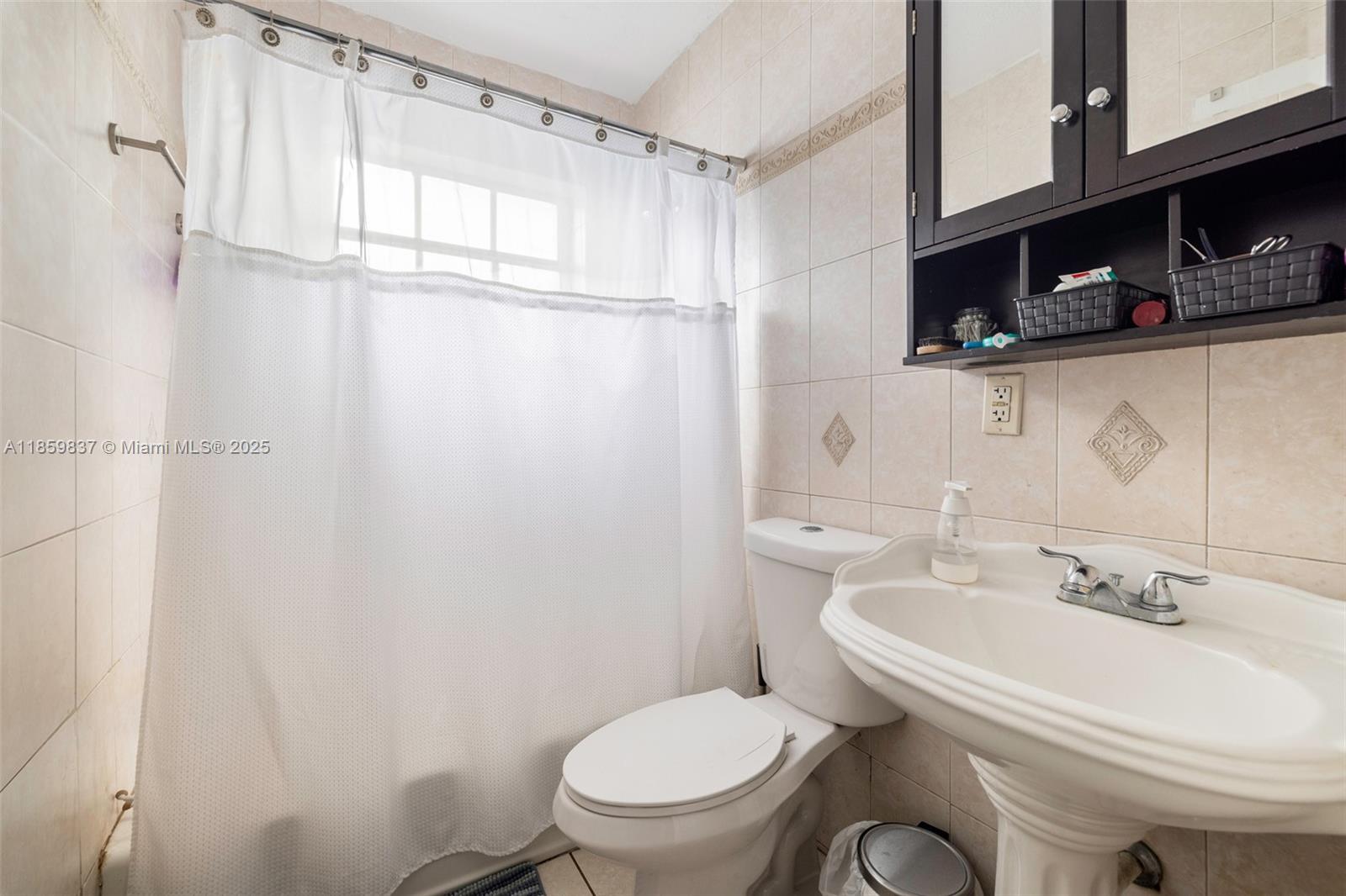 2928 Southwest 5th Street, Unit C Miami, FL 33135 - Photo 9 of 15 a white toilet sitting next to a bathroom sink