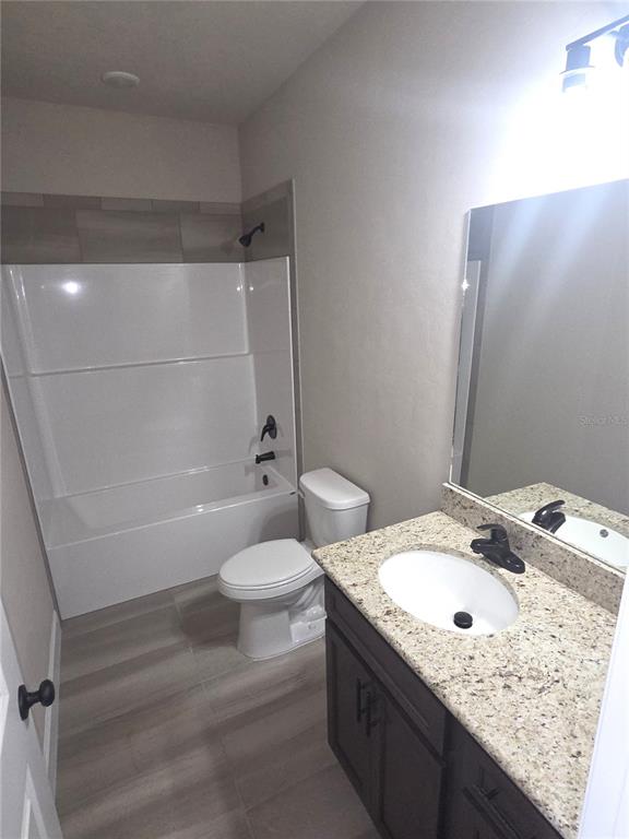24338 Southwest 18th Road Newberry, FL 32669 - Photo 12 of 20 a bathroom with a granite countertop sink toilet and shower