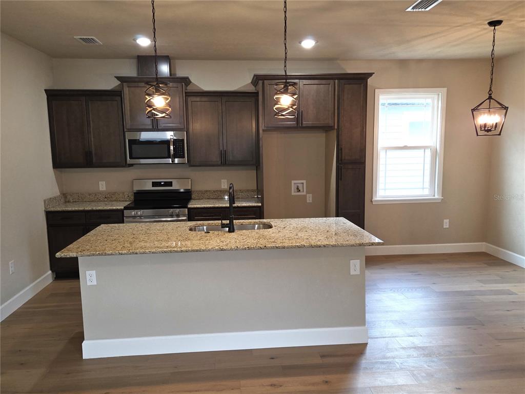 24338 Southwest 18th Road Newberry, FL 32669 - Photo 4 of 20 a view of a kitchen counter top space a sink appliances and a window