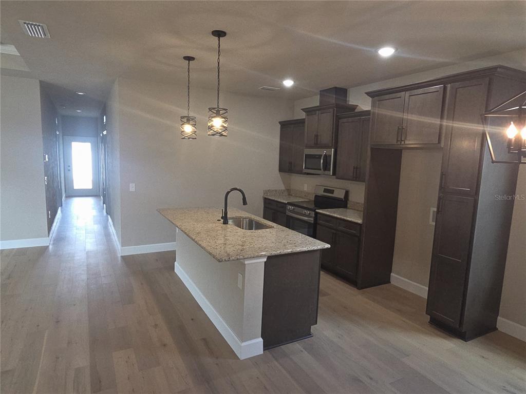 24338 Southwest 18th Road Newberry, FL 32669 - Photo 6 of 20 a kitchen with stainless steel appliances granite countertop a sink and a refrigerator