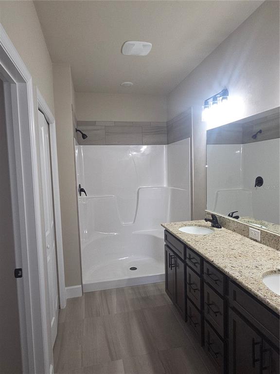 24338 Southwest 18th Road Newberry, FL 32669 - Photo 10 of 20 a bathroom with a granite countertop sink a mirror and a shower