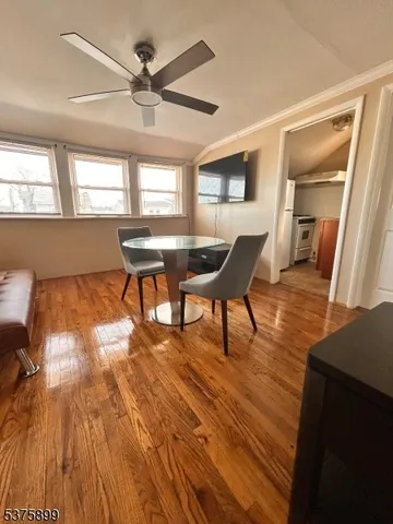 a living room with furniture a large window and wooden floor