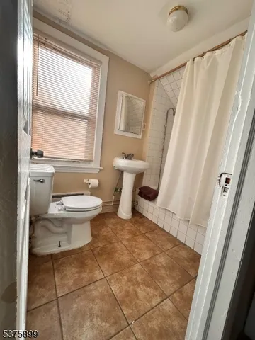 a bathroom with a toilet a window and a shower
