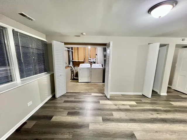 a view of a livingroom with wooden floor and furniture