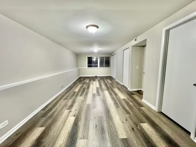 a view of a room with wooden floor