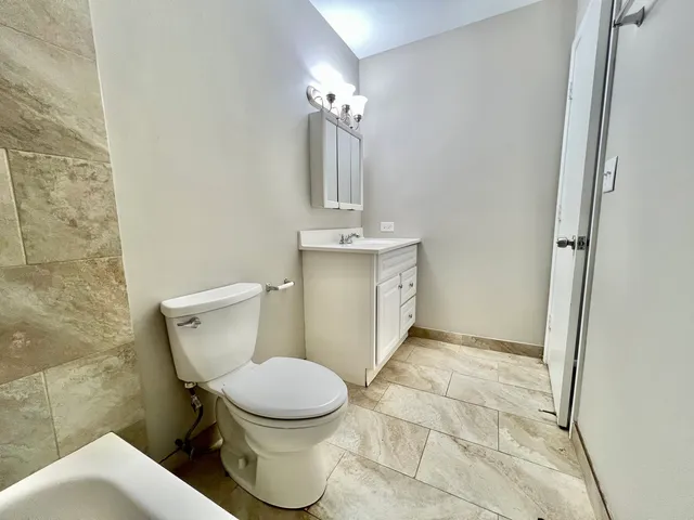 a white toilet sitting next to a bathroom sink