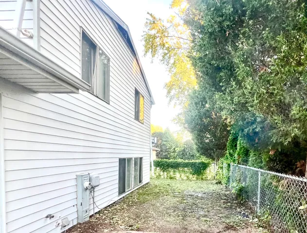 a view of a house with a yard and wooden fence