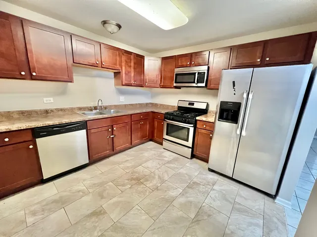 a kitchen with stainless steel appliances granite countertop a refrigerator sink and microwave