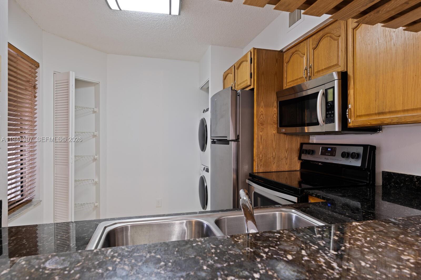 9500 Southwest 140th Court, Unit 9500 Miami, FL 33186 - Photo 9 of 21 a kitchen with stainless steel appliances granite countertop a sink stove and microwave