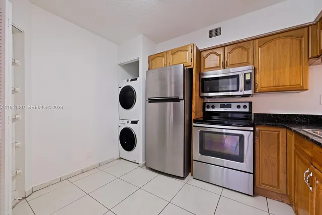 a kitchen with stainless steel appliances granite countertop a refrigerator and a stove top oven