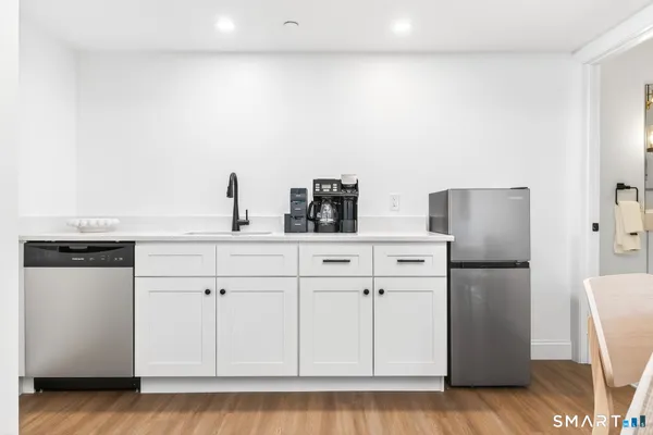 a kitchen with stainless steel appliances white cabinets and a refrigerator