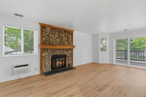 a view of an empty room with a fireplace and a window