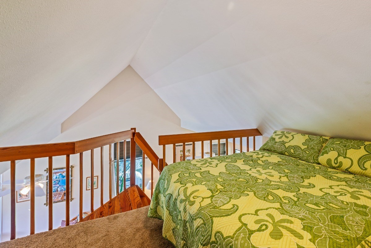 5301 Ka Haku Road, Unit 208 Princeville, HI 96722 - Photo 15 of 27 a bed sitting in a bedroom next to a small yard