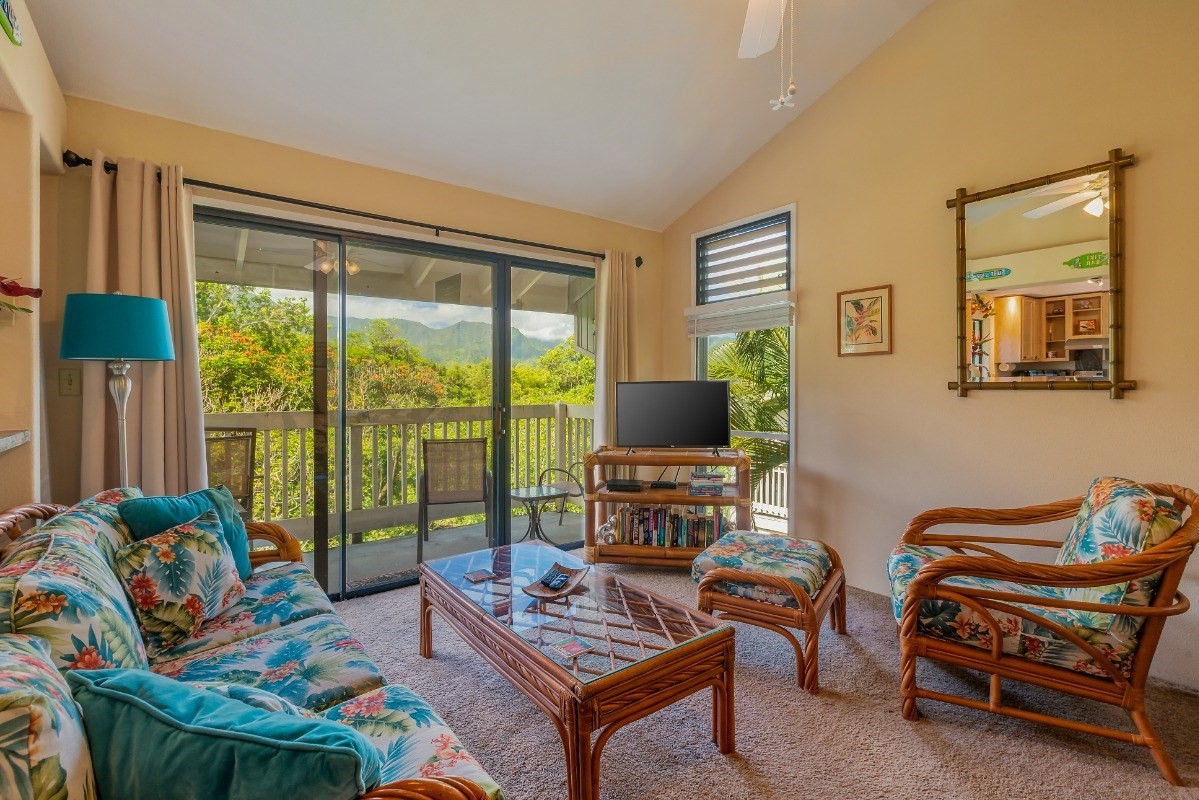 5301 Ka Haku Road, Unit 208 Princeville, HI 96722 - Photo 2 of 27 a living room with furniture a flat screen tv and a floor to ceiling window