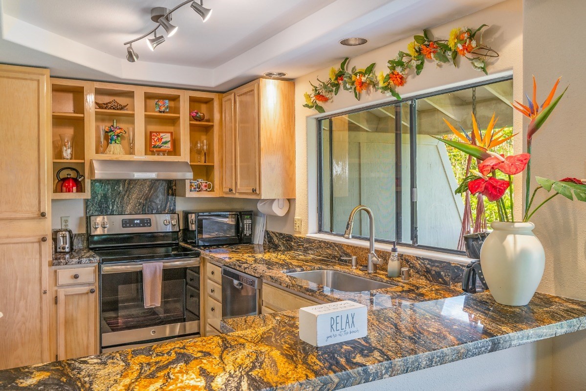 5301 Ka Haku Road, Unit 208 Princeville, HI 96722 - Photo 6 of 27 a kitchen with stainless steel appliances granite countertop a stove and a sink