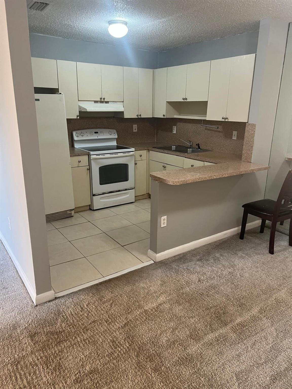 Undisclosed Address Hialeah, FL 33015 - Photo 2 of 7 a kitchen with granite countertop a stove a sink and a refrigerator