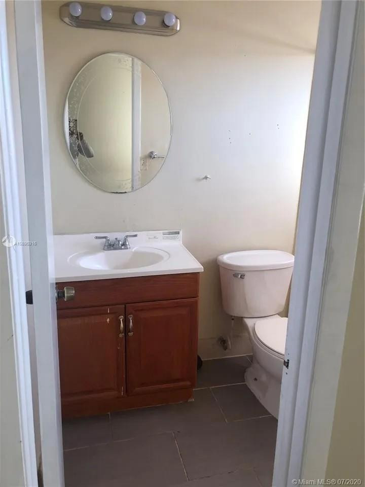 Undisclosed Address Hialeah, FL 33015 - Photo 5 of 7 a bathroom with a sink vanity mirror and toilet