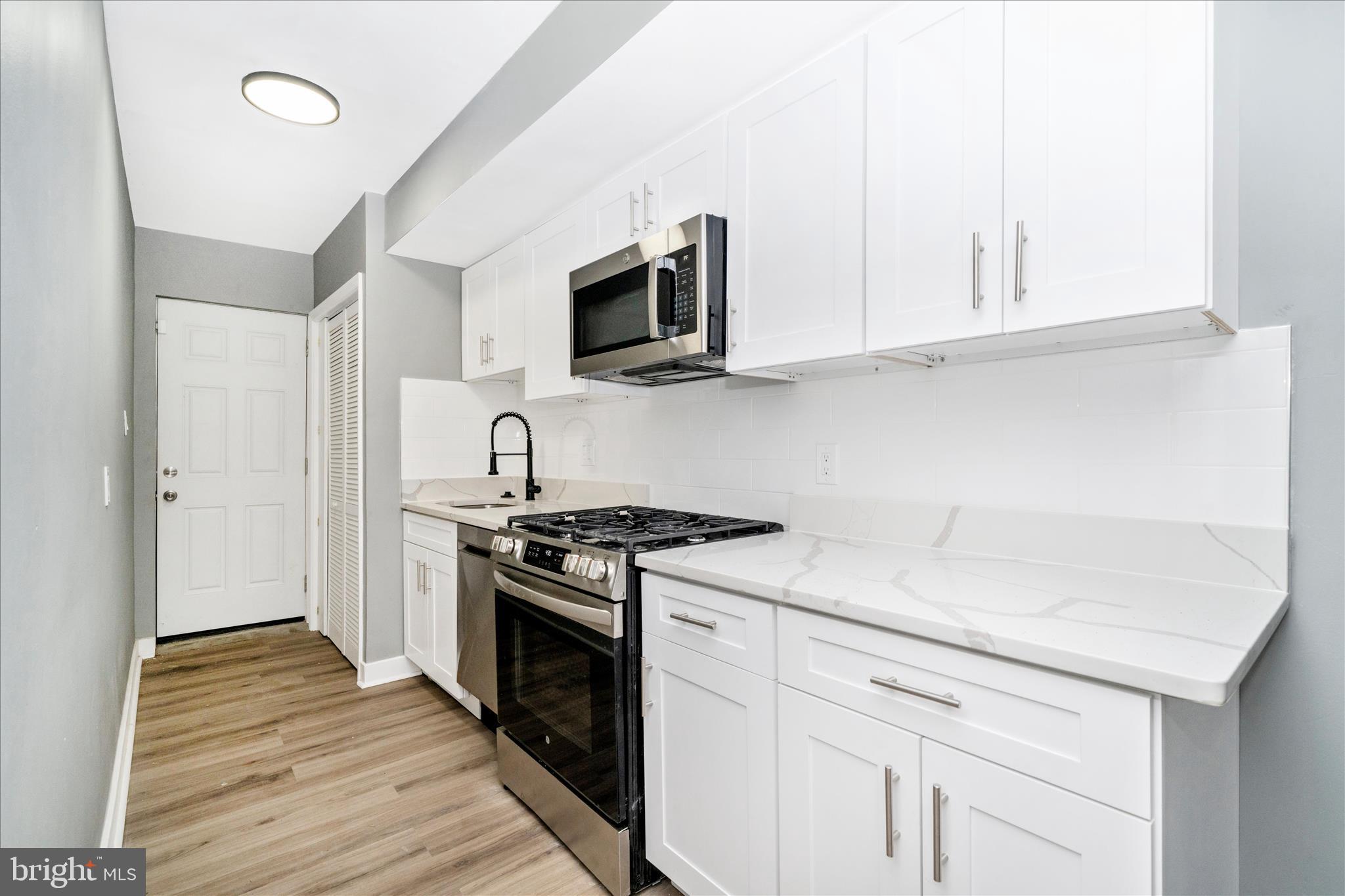 5027 Benning Road Southeast Washington, DC 20019 - Photo 15 of 57 a kitchen with stainless steel appliances granite countertop a sink and a stove top oven