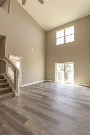 an empty room with stairs and wooden floor