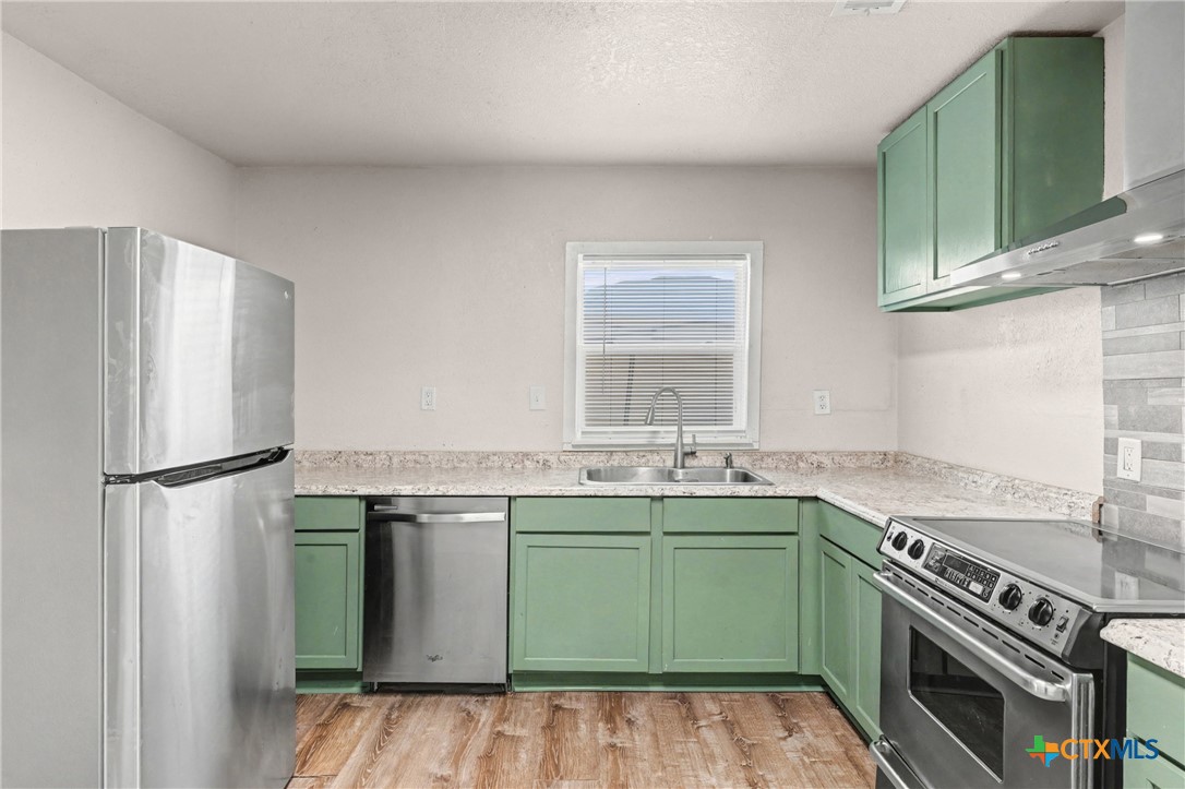 906 South 2nd Street Temple, TX 76504 - Photo 12 of 41 a kitchen with a sink and a refrigerator