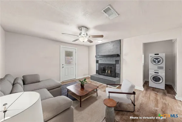 a view of an empty room with a fireplace and a chandelier fan