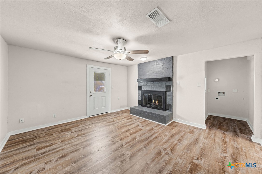 906 South 2nd Street Temple, TX 76504 - Photo 18 of 41 a view of an empty room with a fireplace and a chandelier fan