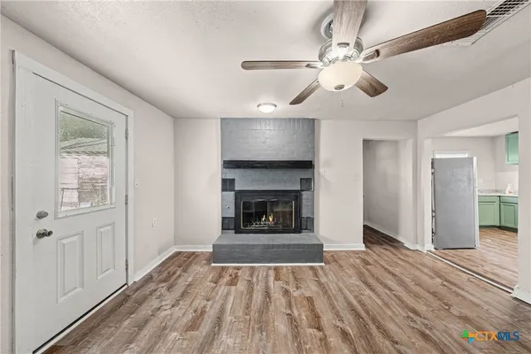 a view of a hallway with wooden floor and a fireplace