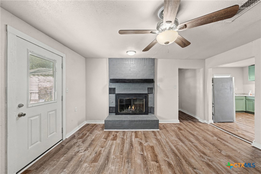 906 South 2nd Street Temple, TX 76504 - Photo 19 of 41 a view of an empty room with wooden floor fireplace and a window