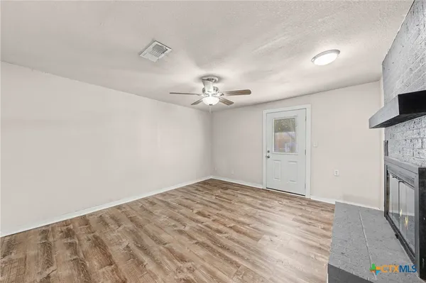 a view of an empty room with window and fire place