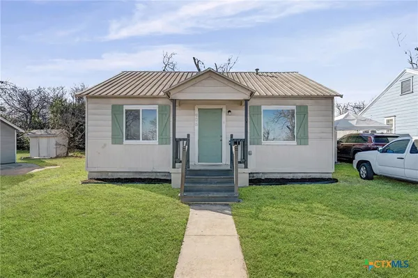 a view of a house with a yard and sitting area