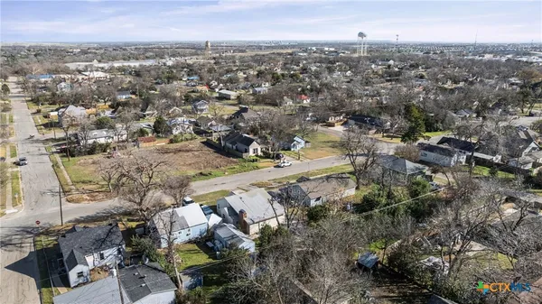 an aerial view of a house with a yard and lake view