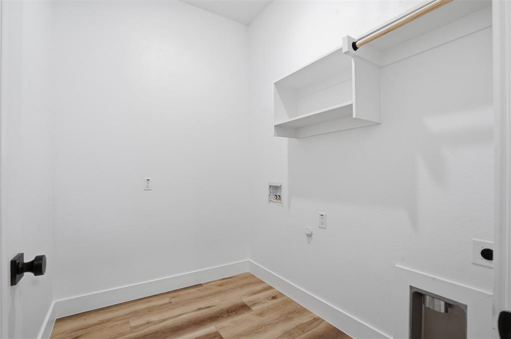 1111 Riverwood Road Dallas, TX 75217 - Photo 29 of 40 Dedicated laundry space featuring wood-finish flooring, white walls, and built-in shelving
