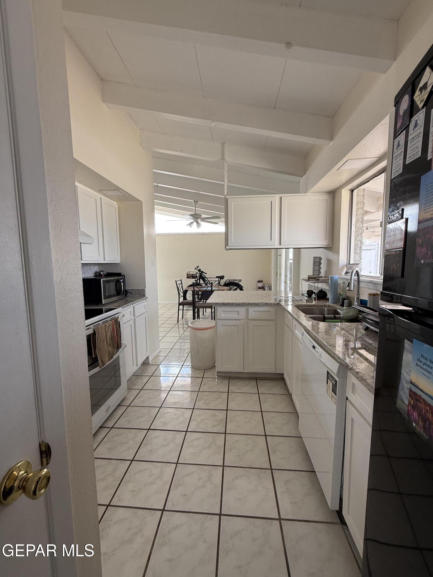 313 Clairemont Road El Paso, TX 79912 - Photo 17 of 34 a kitchen with a sink a counter top space cabinets and stainless steel appliances