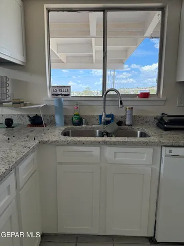 a kitchen with stainless steel appliances granite countertop a sink a stove and a wooden cabinets