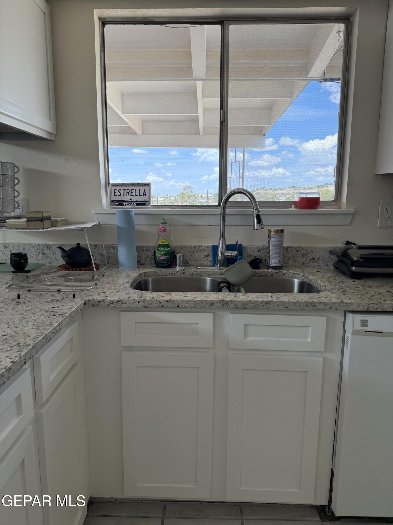 313 Clairemont Road El Paso, TX 79912 - Photo 20 of 34 a kitchen with stainless steel appliances granite countertop a sink a stove and a wooden cabinets