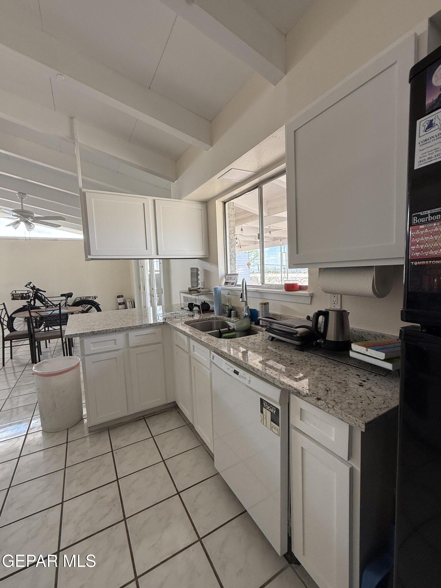 313 Clairemont Road El Paso, TX 79912 - Photo 24 of 34 a kitchen with a sink a stove a microwave and cabinets