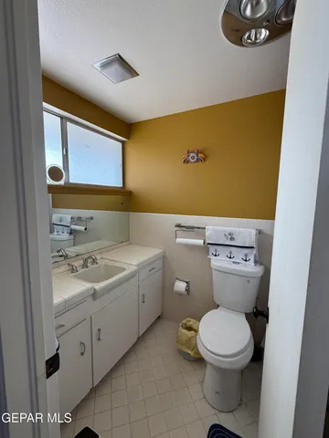 a bathroom with a granite countertop toilet and a sink