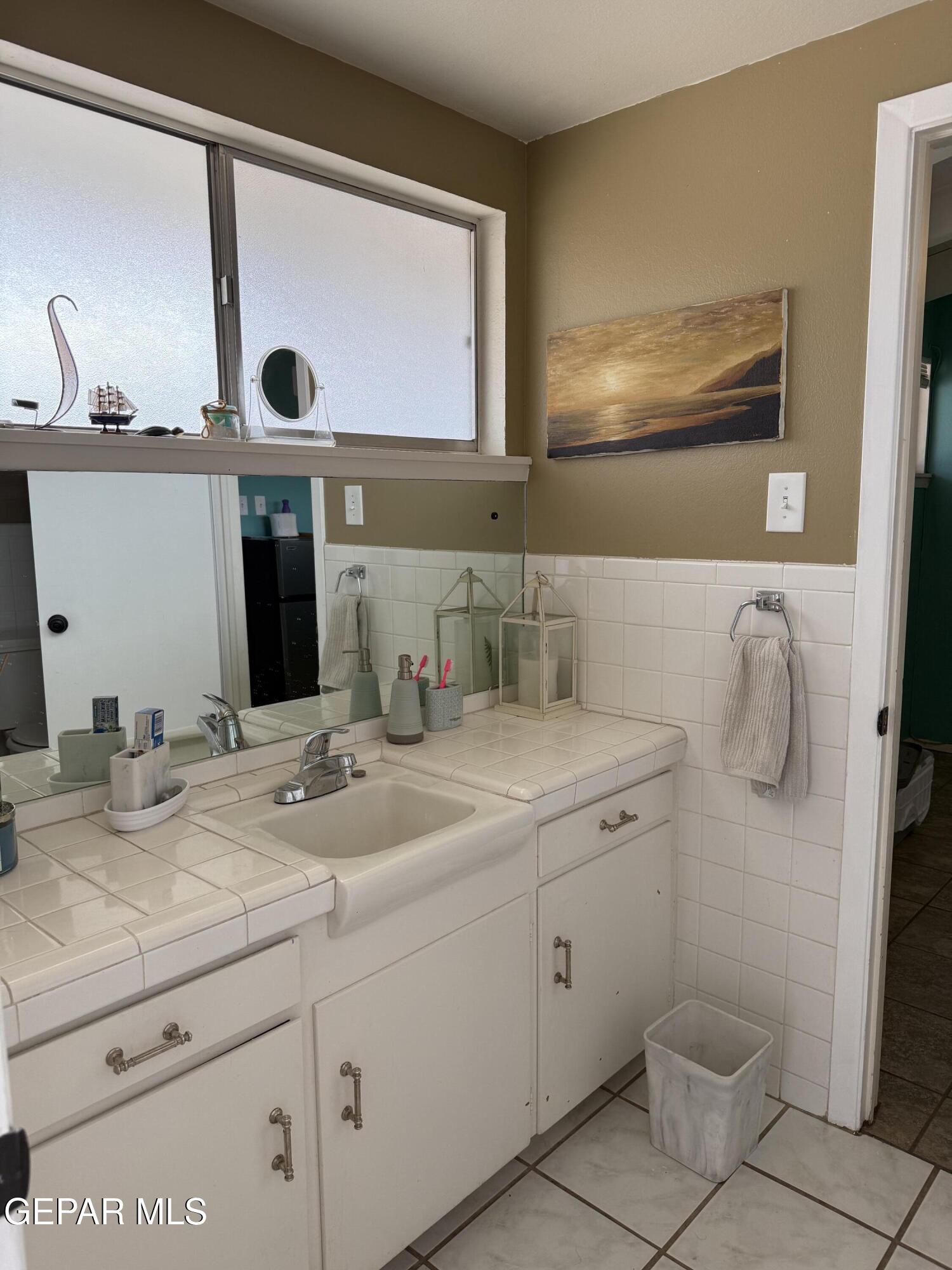 313 Clairemont Road El Paso, TX 79912 - Photo 9 of 34 a bathroom with a granite countertop sink and a mirror