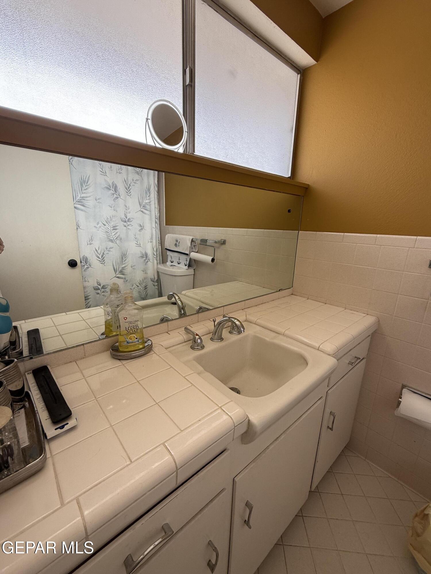313 Clairemont Road El Paso, TX 79912 - Photo 10 of 34 a bathroom with a sink and a mirror
