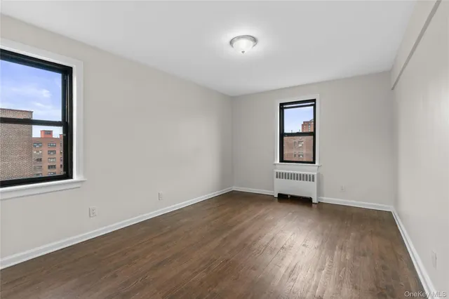 an empty room with wooden floor and window
