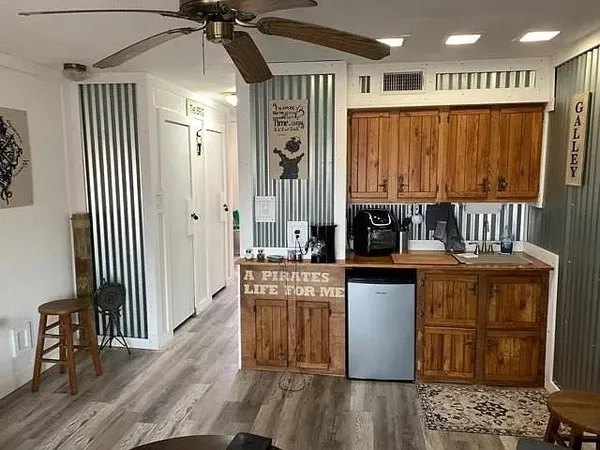 a kitchen with stainless steel appliances granite countertop a refrigerator a sink dishwasher a stove and white cabinets with wooden floor