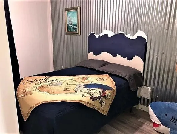 a bed sitting in a bedroom next to a window with wooden floor