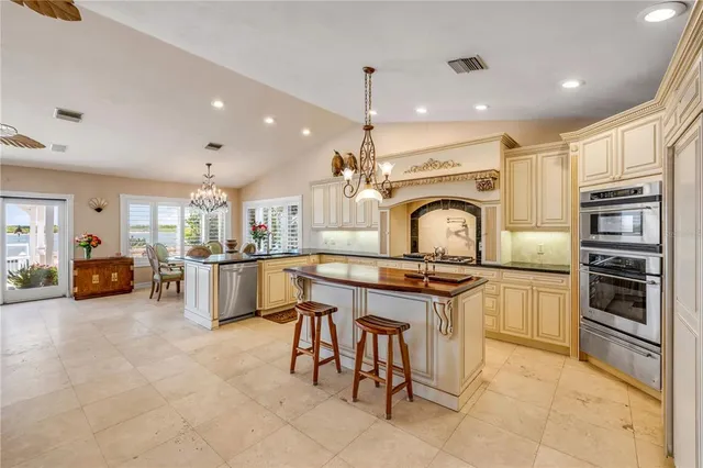 a kitchen with kitchen island granite countertop lots of counter top space and stainless steel appliances