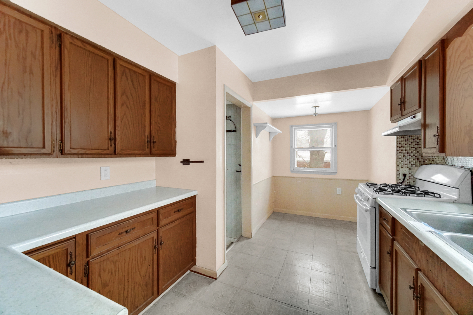 1009 Augusta Avenue Elgin, IL 60120 - Photo 13 of 24 a kitchen with stainless steel appliances granite countertop a sink stove and cabinets