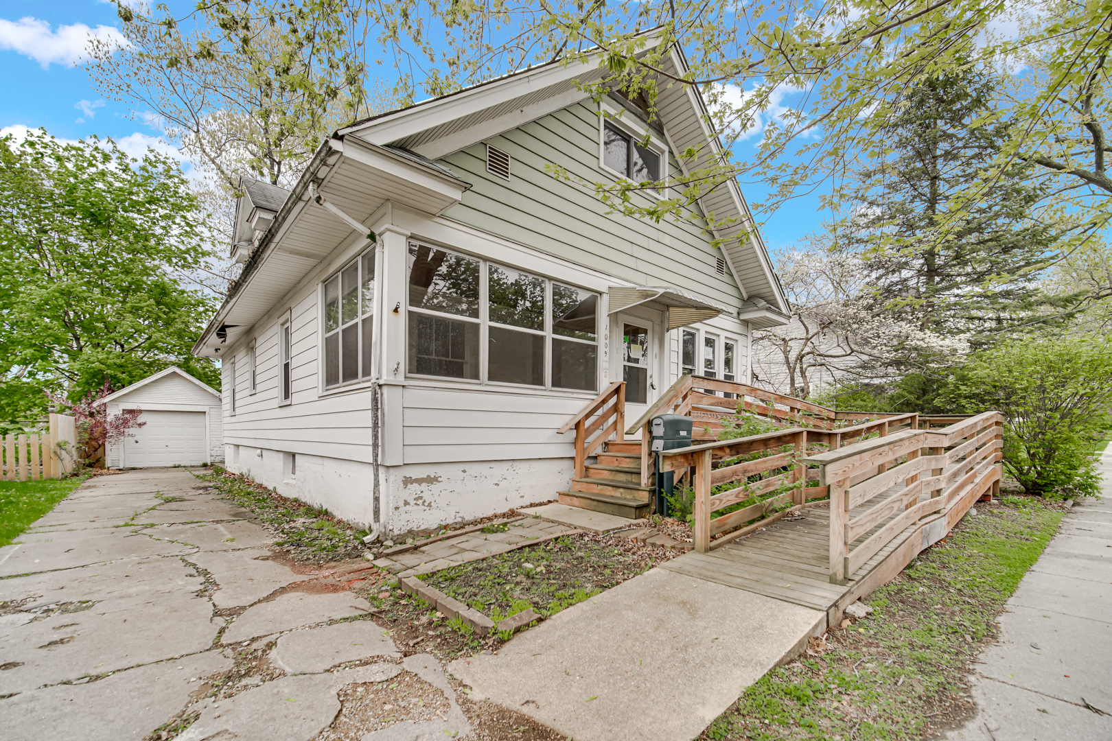 1009 Augusta Avenue Elgin, IL 60120 - Photo 2 of 24 a view of a white house with large windows and a small yard