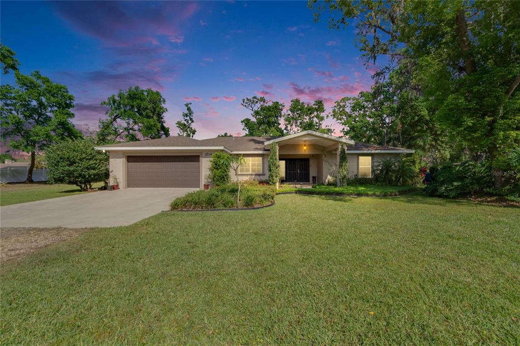 a front view of a house with a garden and yard