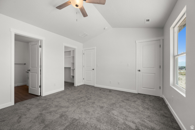 1554 Pheasant Road Eagle Mountain, UT 84005 - Photo 17 of 29 Unfurnished bedroom featuring a walk in closet, dark carpet, and ceiling fan